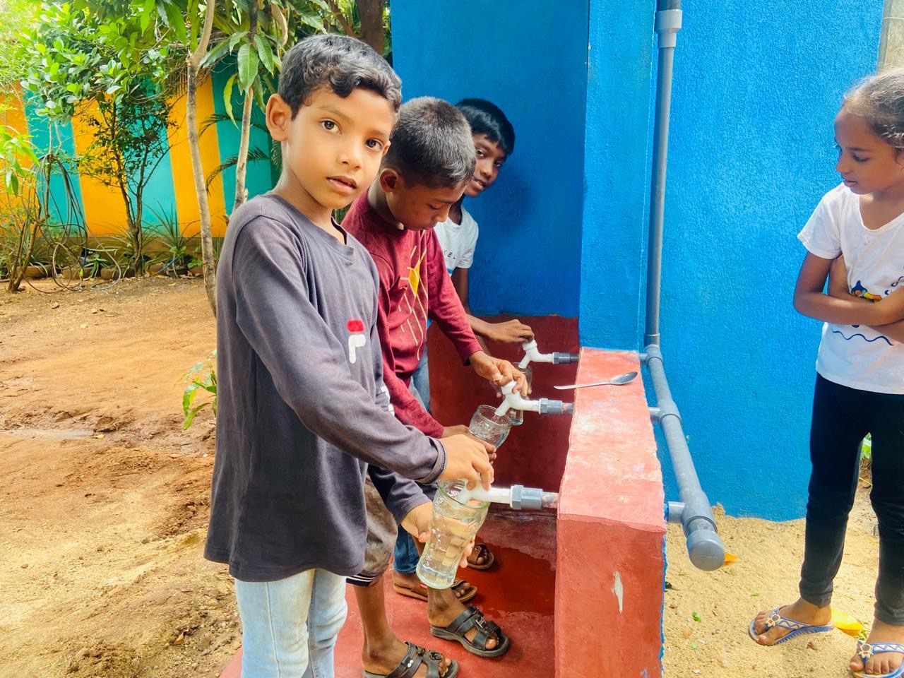 enfants buvant d'un puits construits au Sri Lanka